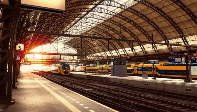 Platform of Amsterdam Central Station, with NS trains on the railways behind.