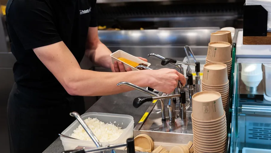 Woman loading fries with sauce at Patatzaak in Sloten