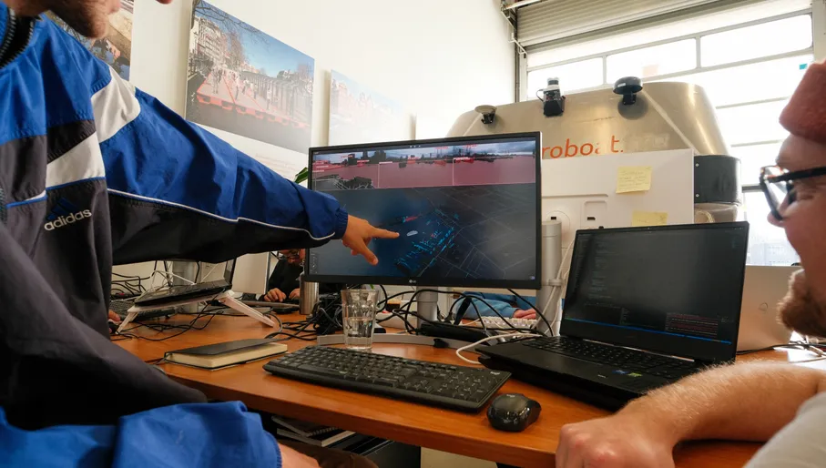 Two people pointing at a computer screen