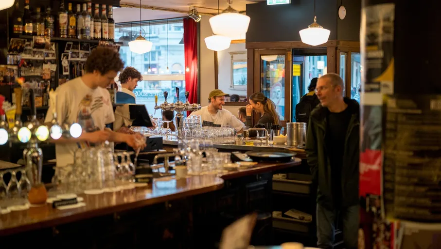 People sitting inside brown bar Café Koosje