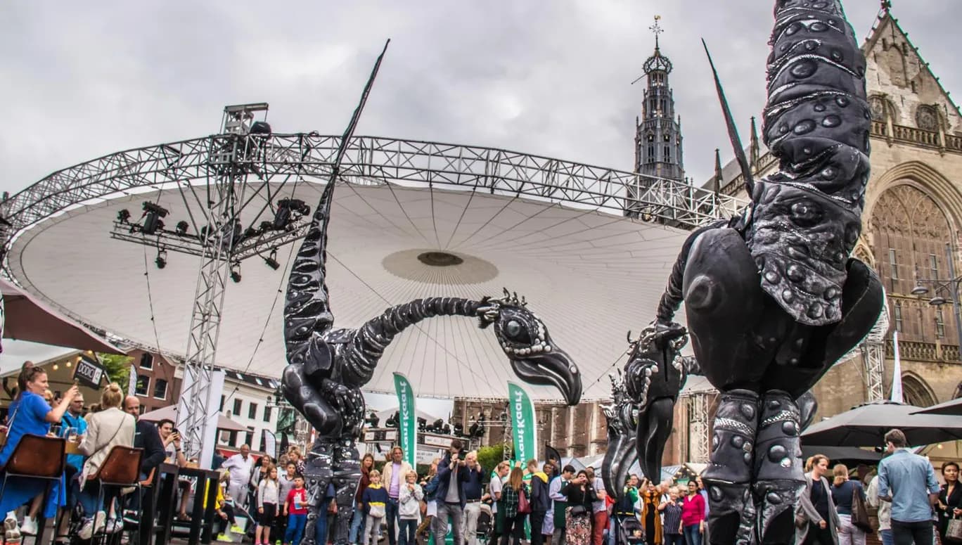 Grote Markt, Haarlem, Haarlem Culinair. Performers and art installations with visitors enjoying food at drinks at Haarlem Culinair food festival at the Grote Markt