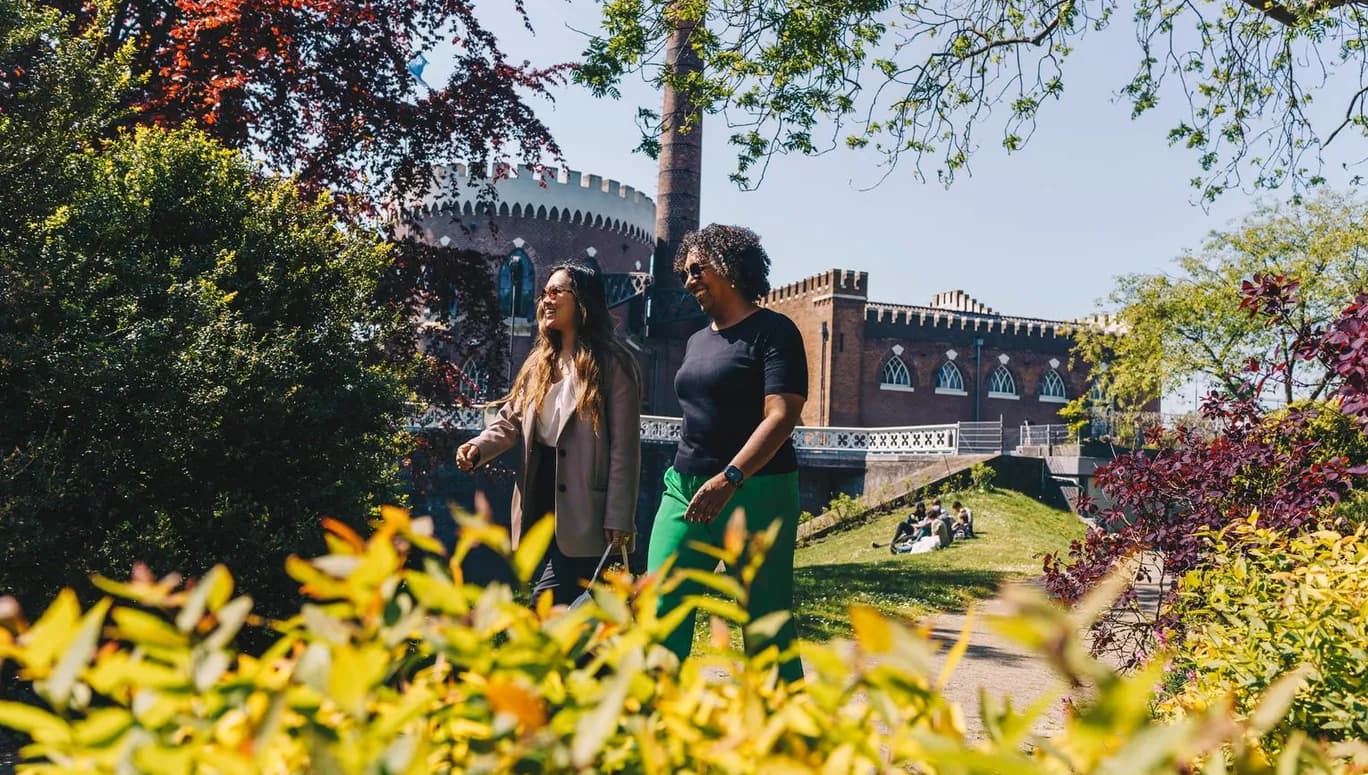Two women walking past Haarlemmermeermuseum De Cruquius.
