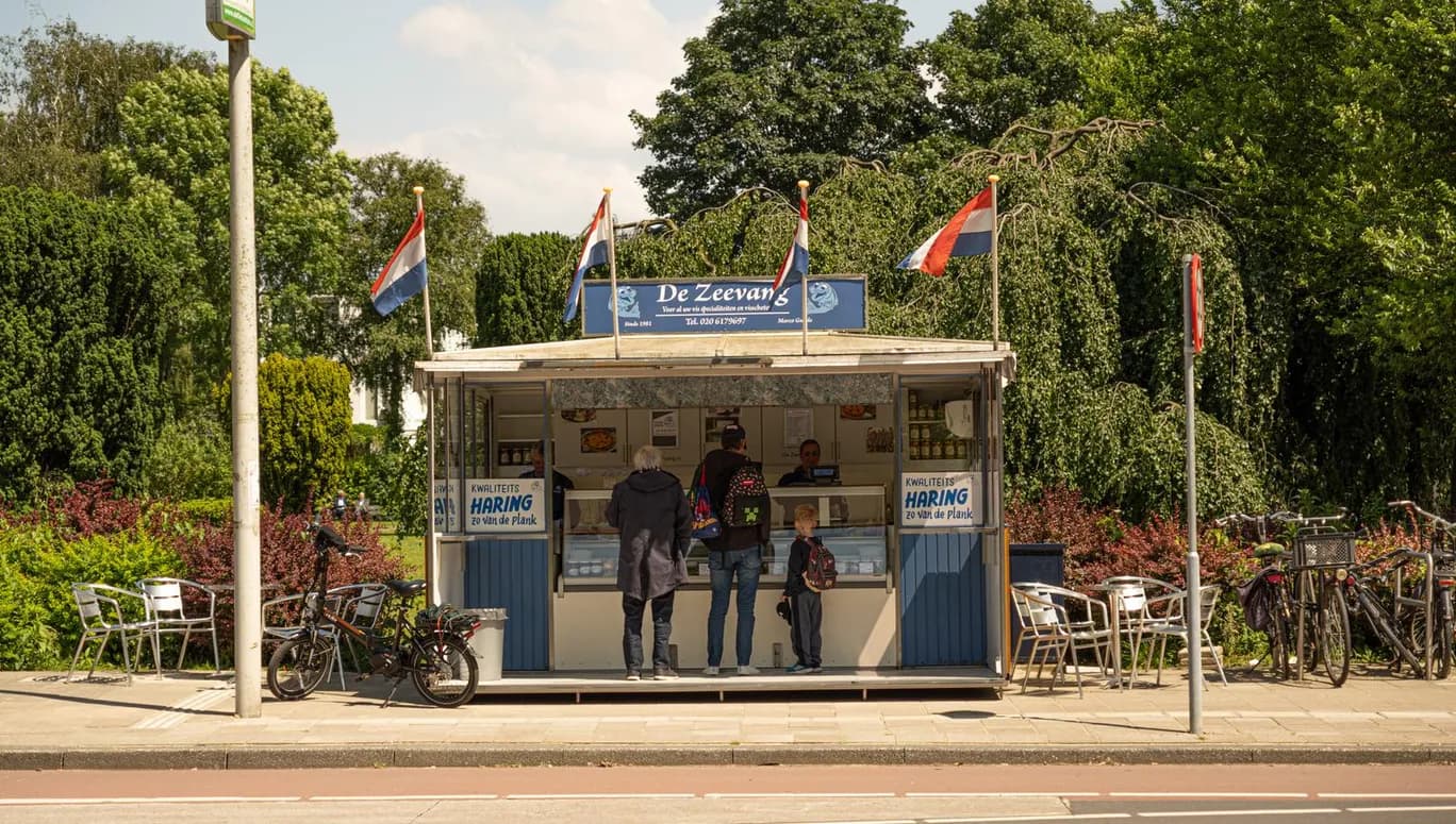 Family lining up to order some delicious herring from the Zeevang haringhandel on Haarlemmermeerstraat.