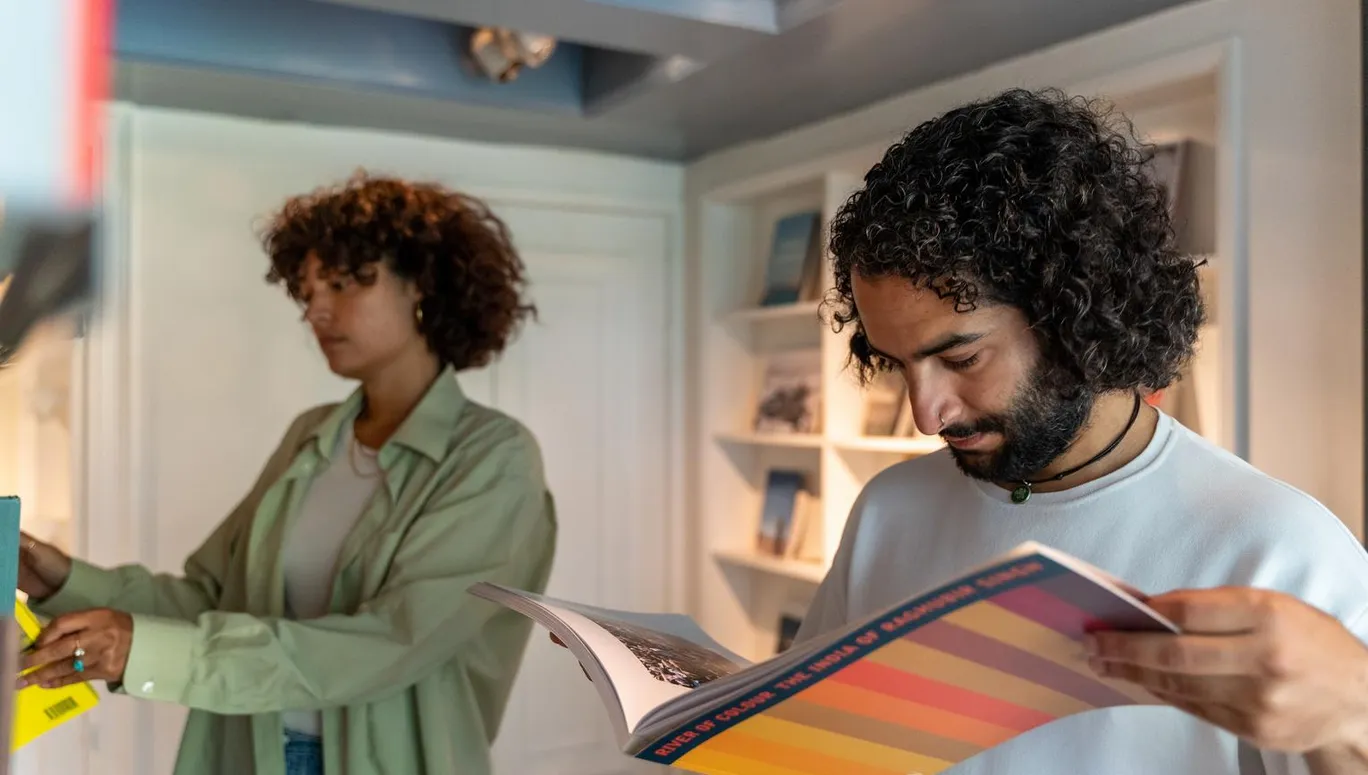 A couple reading books in the museum shop of Huis Marseille.