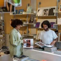 A couple checks out the books of the museum shop of Huis Marseille.