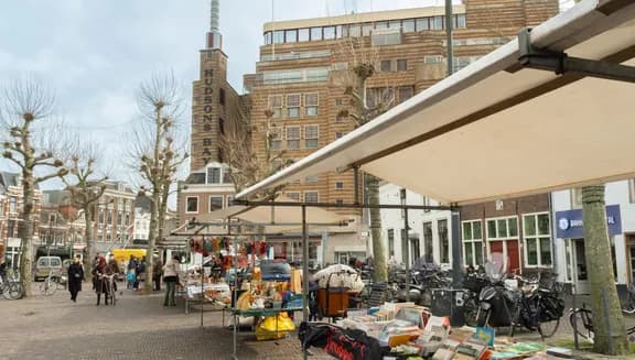 Books for sale and people shopping at the Botermarkt Flea Market. Haarlem Content Creation Day March 2024