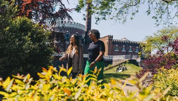 Two women walking past Haarlemmermeermuseum De Cruquius.