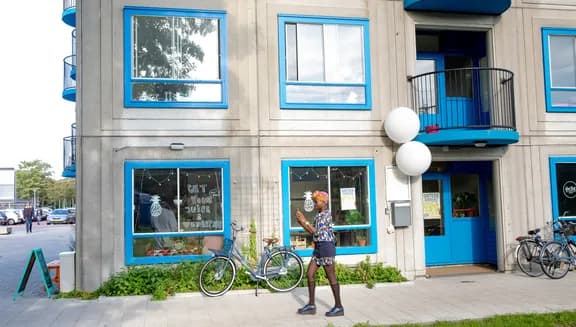 A woman walking infront of the Juicety building