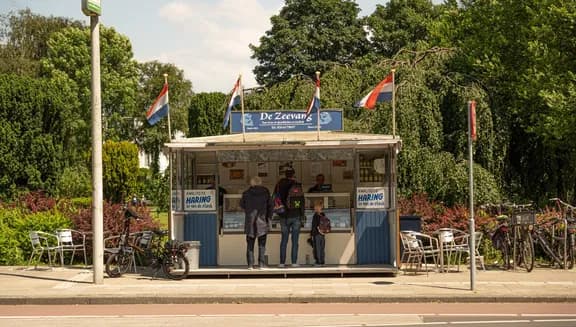 Family lining up to order some delicious herring from the Zeevang haringhandel on Haarlemmermeerstraat.
