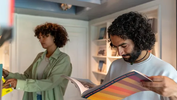 A couple reading books in the museum shop of Huis Marseille.
