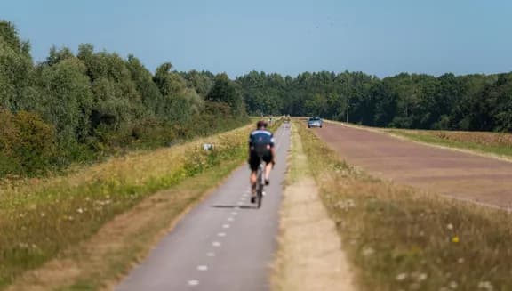 A cyclist on De Knardijk. An inner dike that forms the border between eastern and southern Flevoland as a land divide.