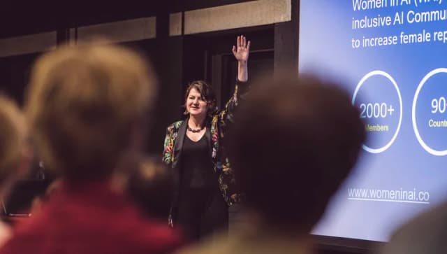 Eve Logunova of Women in AI presenting on stage at event.