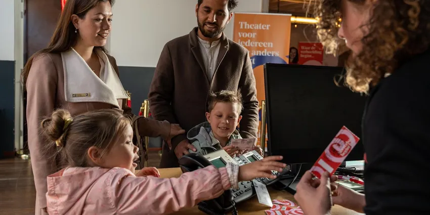 A family receive tickets for a play at Theater De Krakeling