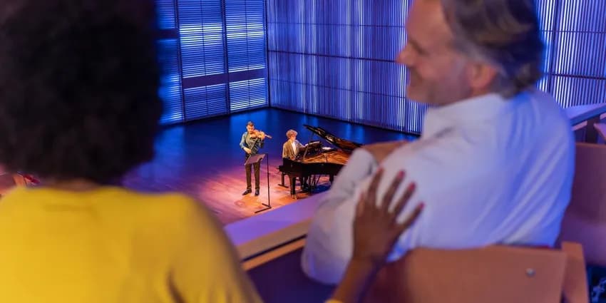 A couple enjoys a concert in het Muziekgebouw aan 't IJ.