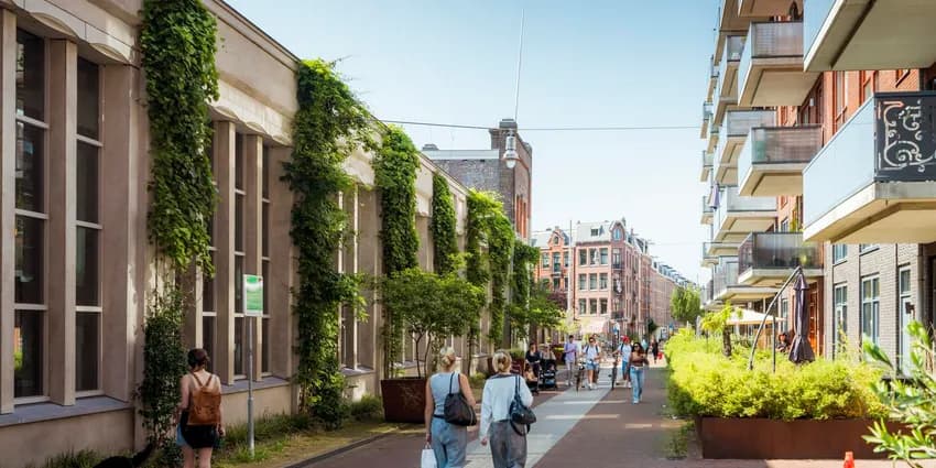 People walking over Hannie Dankbaarpassage next to De Hallen.