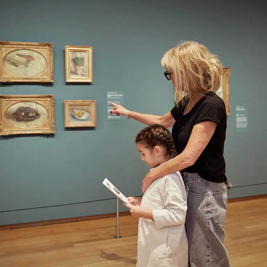 An adult and a girl are visiting Van Gogh Museum.