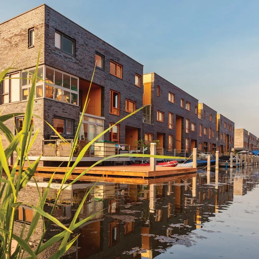 Row of Dutch modern canal houses in Almere reflected in the water