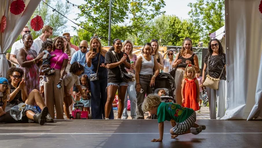 Parents watch while a boy shows his breakdance skills in the Kids Village at Kwaku Summer Festival 2024.