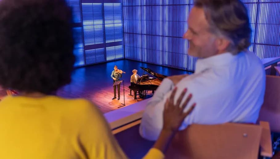 A couple enjoys a concert in het Muziekgebouw aan 't IJ.