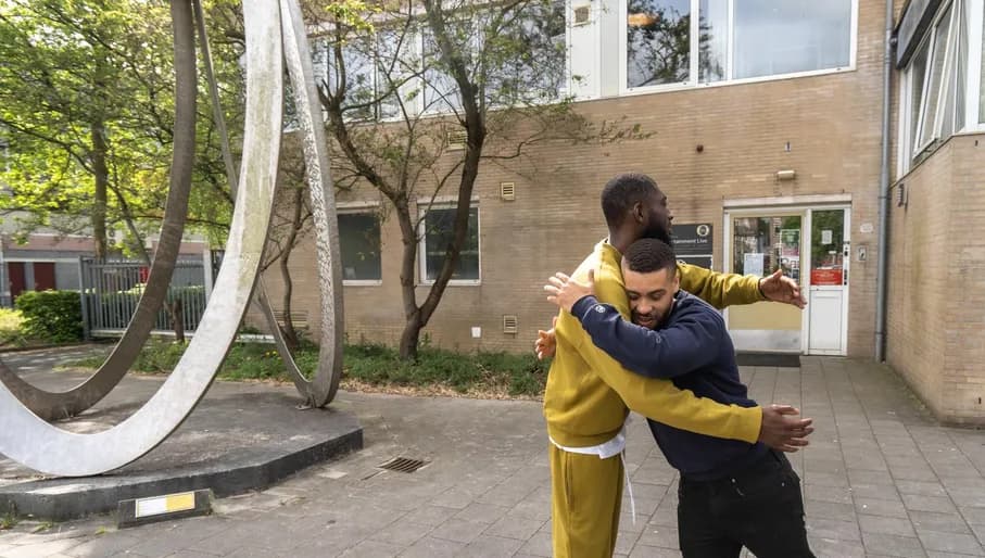 Two men hugging outside at Kazerne Reigersbos