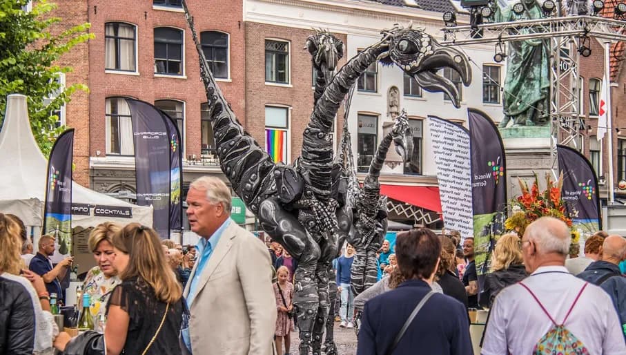 Grote Markt, Haarlem, Haarlem Culinair. Performers and art installations with visitors enjoying food at drinks at Haarlem Culinair food festival at the Grote Markt