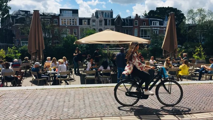 Blend Coffee & Wine people sitting on the terrace while someone bikes past