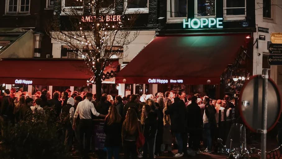 Café Hoppe people standing outside by night