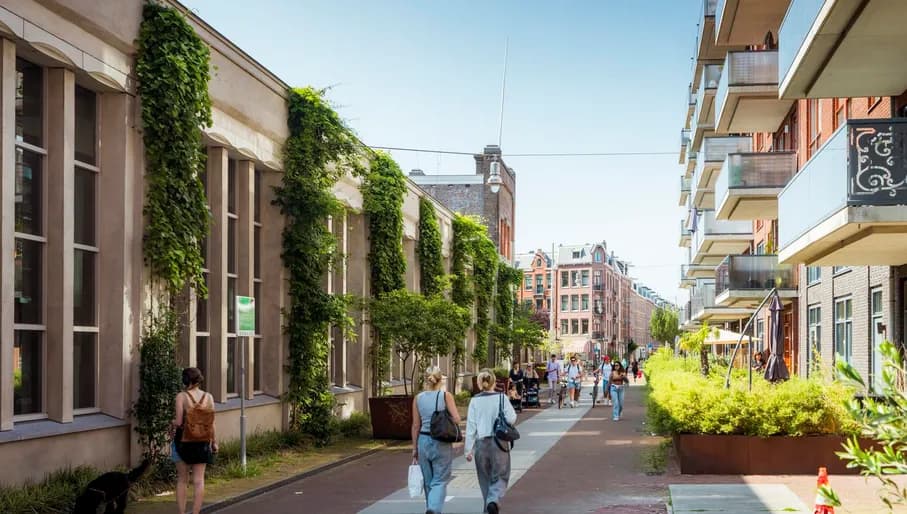 People walking over Hannie Dankbaarpassage next to De Hallen.