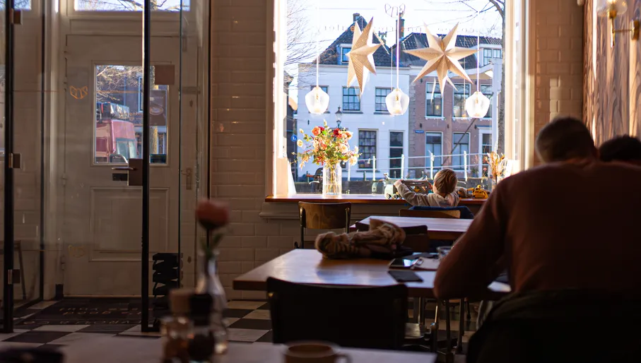 Child playing in the window at Mevrouw & Co cafe in Weesp