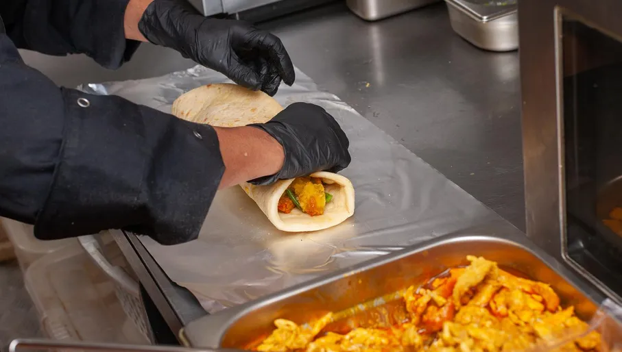 Chef preparing food at Rotishop Gieta