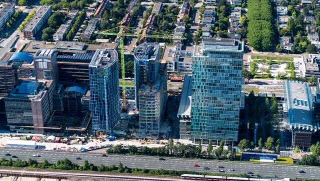 13 July 2020, Amsterdam, Holland. Aerial view of construction site of new skyscraper apartment complex 2AMSTERDAM next to Atrium at the Amsterdam Zuidas