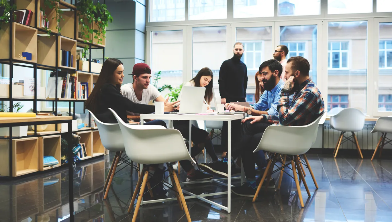 Group of casually dressed businesspeople discussing ideas in the office. Creative professionals gathered at the meeting table for discuss the important issues of the new successful startup project