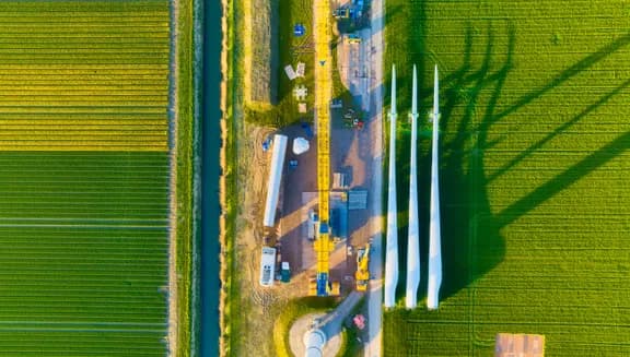 Construction and installation of a wind turbine. Production of clean green energy. Technology and innovation. Aerial view. Industrial landscape from a drone. Top view.