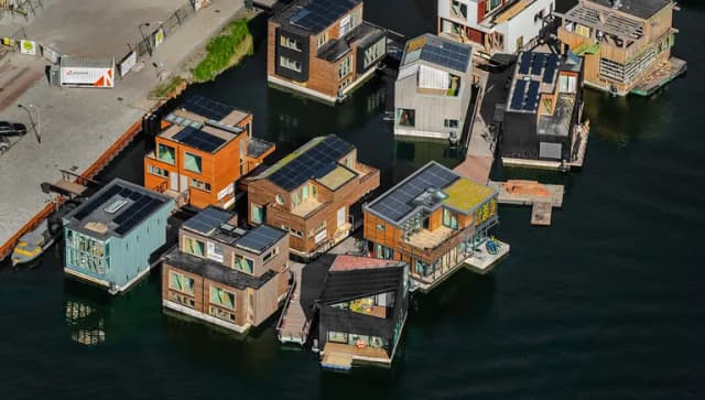 De dertien waterwoningen zijn door zes verschillende ontwerp partijen ontworpen, wat een divers aanzicht geeft. Allemaal hebben ze een betonnen drijflichaam en een opbouw van houtskeletbouw. Er zijn circa 500 zonnepanelen geïnstalleerd op de daken en douchen en afwassen gebeurt als het kan met opgevangen regenwater in een spaardouche. Het particulier opdrachtgeverschap Schoonschip bouwde samen met Bouwbedrijf van Middendorp deze drijvende wijk die in 2019 is opgeleverd. Foto John Gundlach.