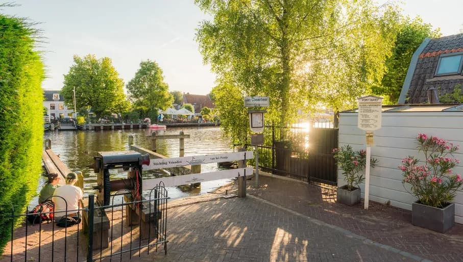 A couple sitting near the river bank of the Amstel in the village of Oudekerk aan de Amstel.