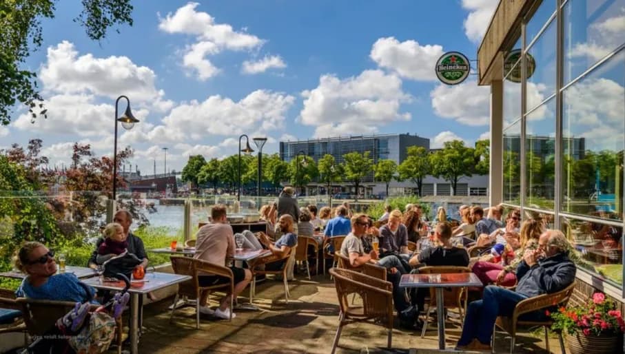 People sitting on the terrace of Pension Homeland at the Marineterrein